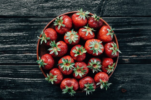 Fresas rojas maduras en una placa de madera