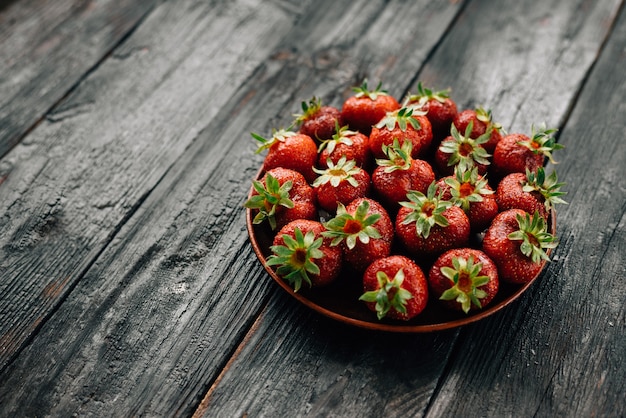 Fresas rojas maduras en una placa de madera