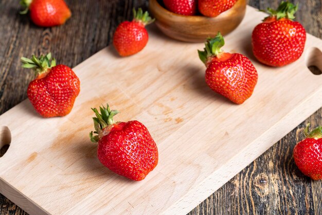 Fresas rojas maduras sobre una bandeja de madera