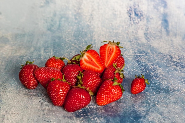 Fresas rojas maduras sobre un fondo azul.