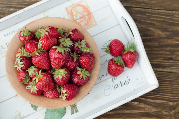 Fresas rojas maduras sobre mesa de madera