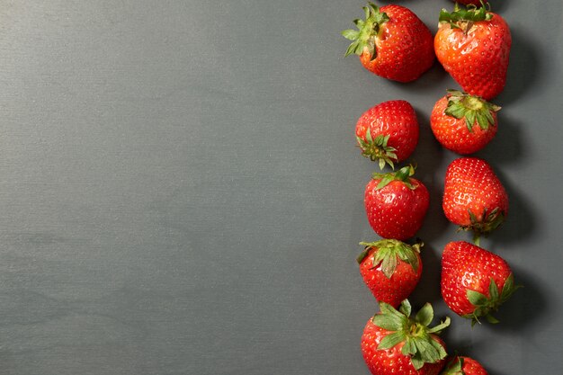 Fresas rojas recién cosechadas sobre fondo gris