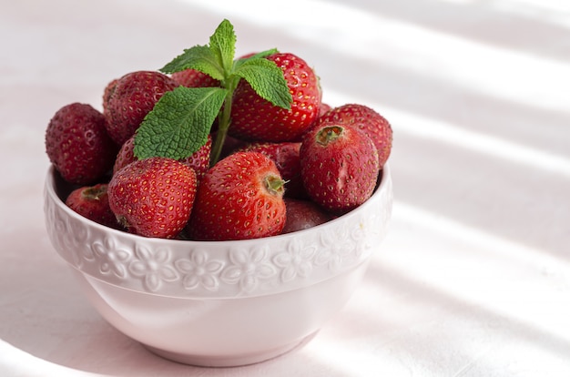 Fresas sanas y frescas en un tazón con menta