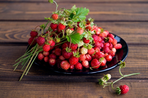 Fresas en una taza blanca en una mesa de madera rústica. El concepto de alimentación ecológica. estilo rústico