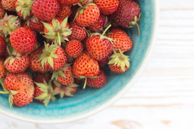 Fresas en un tazón sobre una mesa de madera