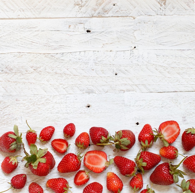 Foto fresas en una vista superior de la mesa de madera blanca