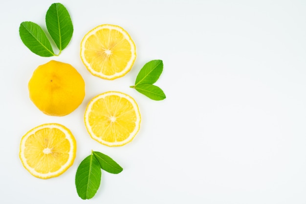 Fresca rodaja de limón con hojas, suplemento de vitamina C natural sobre fondo blanco.