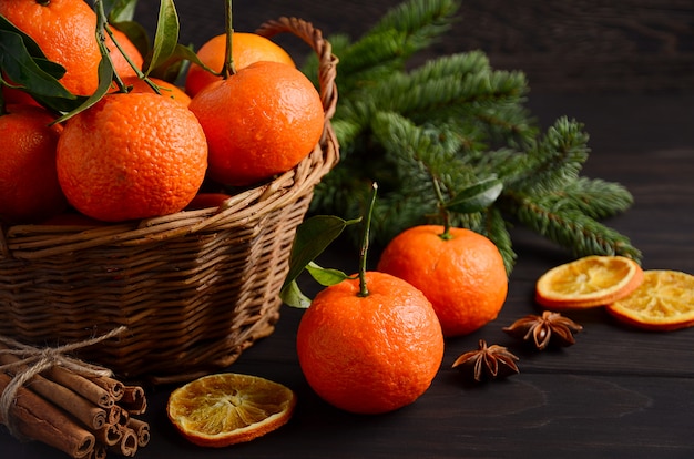 Frescas mandarinas clementinas con especias sobre fondo de madera oscura