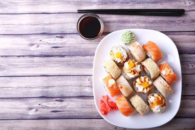 Frescos y sabrosos rollos de sushi japonés tradicional en plato blanco. Vista superior