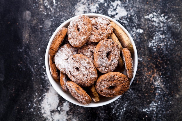 Fresh cozido biscoitos de chocolate e biscoitos de aveia com monte de açúcar em pó em tigela branca