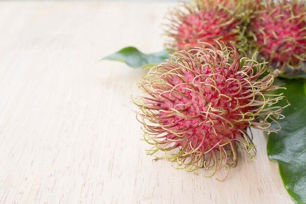 Foto fresh rambutan sobre fondo de madera