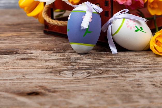 Fresias en una caja y huevos de Pascua sobre un fondo de madera antiguo.