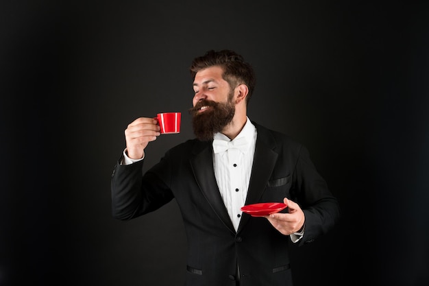Freude am Kaffeetrinken Glücklicher Manager hält Kaffeetasse Bärtiger Mann trinkt gerne Kaffee Heißes Getränk trinken Teetrinken ist gut für Sie Morgen und Frühstück