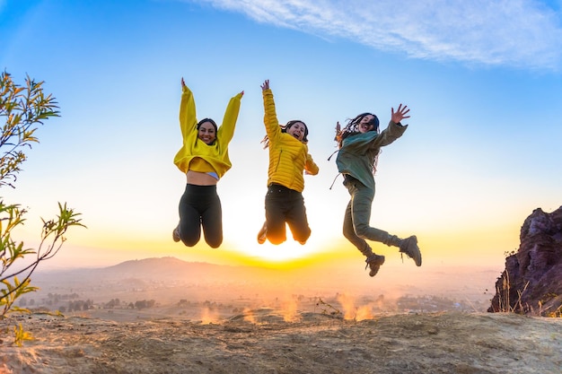 Foto freude und freiheit der jugend spiegeln sich im bild dieser freunde wider, die auf bergpfaden springen.