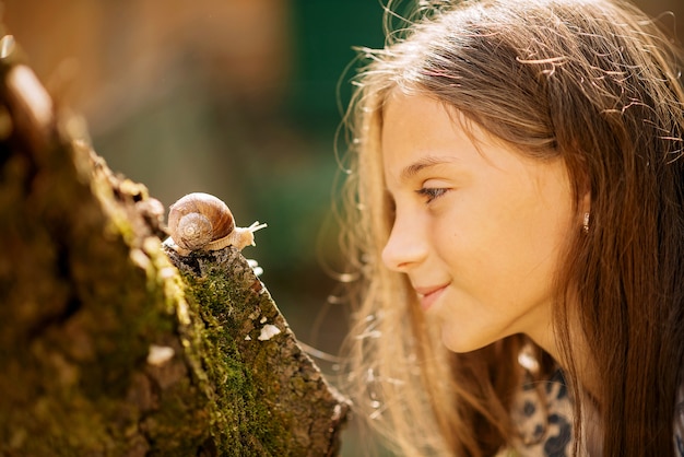 Freudiges Treffen eines kleinen Mädchens und einer Schnecke.