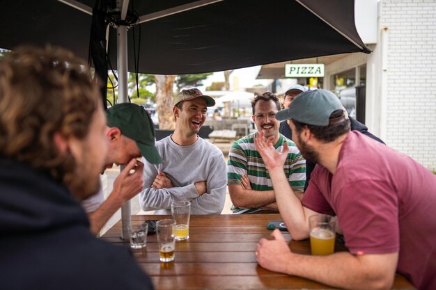 Freunde am Tisch, die eine Wette abschließen, Männer in einem Pub, die in Australien Bier trinken