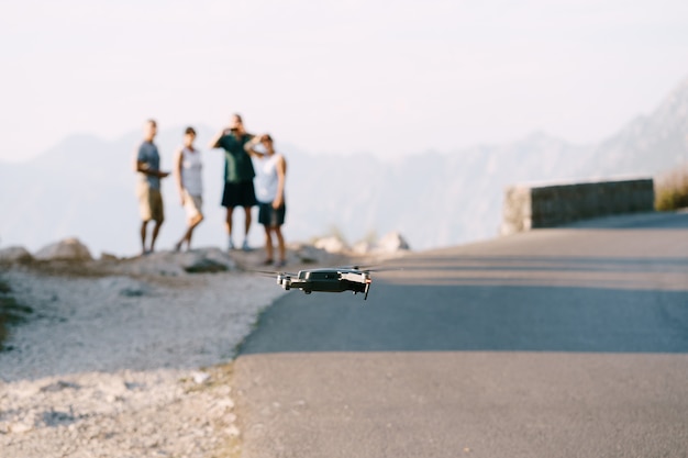 Freunde auf der Straße starten eine Drohne eine Gruppe von Teenagern startet mit einer Drohne, die von der