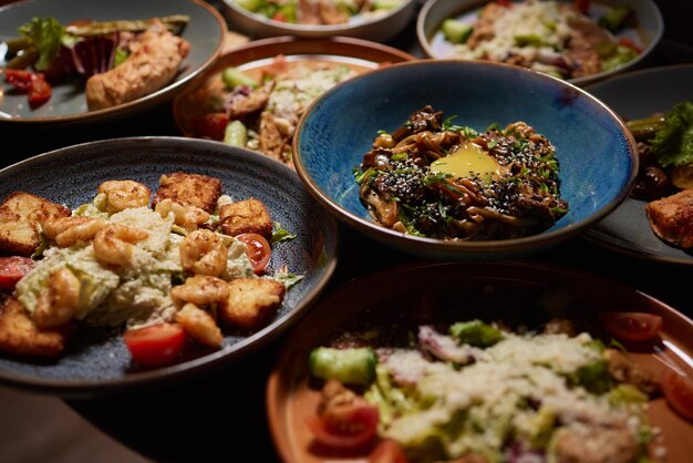 Freunde beim Abendessen Draufsicht von vier Personen, die zusammen zu Abend essen, während sie am rustikalen Holztisch sitzen