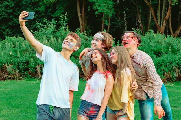 Freunde beim Holi-Fest machen Selfie am Telefon und haben Spaß