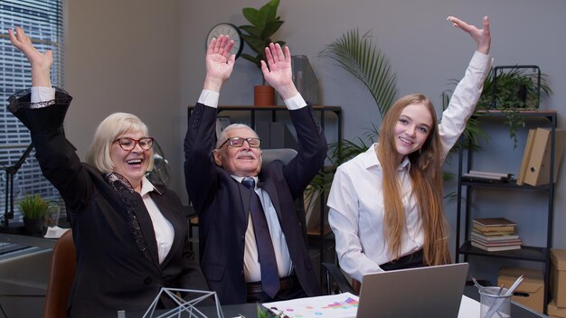 Foto freunde benutzen einen laptop, während sie im büro sitzen