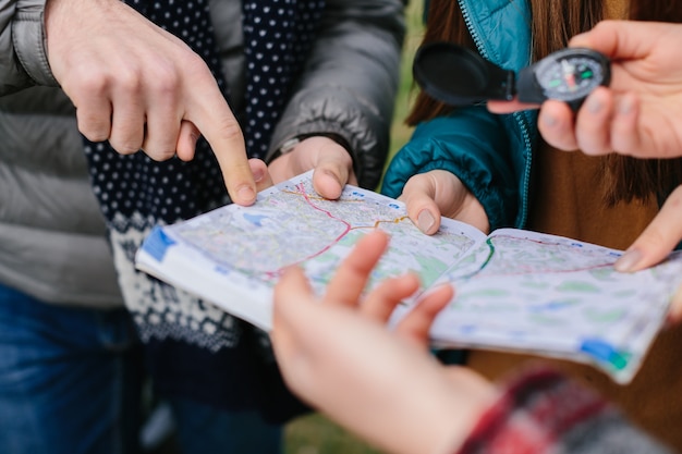 Freunde benutzen Karte und Kompass im Freien