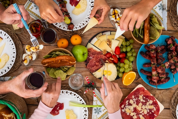 Freunde der Familie haben Spaß zusammen beim Essen auf einem Holztisch