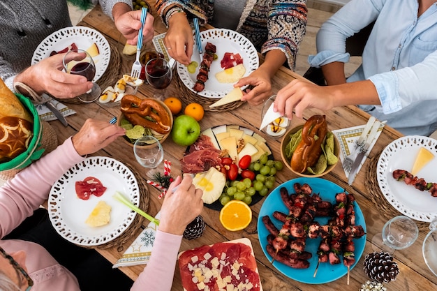 Freunde der Familie haben Spaß zusammen im Winter beim Essen auf einem Holztisch