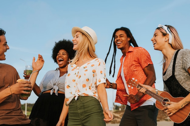 Freunde, die am Strand singen und tanzen