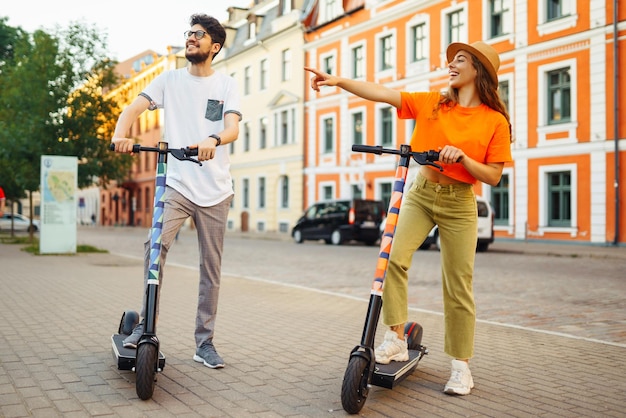 Freunde, die auf einem E-Scooter fahren, um sich gemeinsam im Freien in der Stadt zu entspannen Aktiver Lebensstil