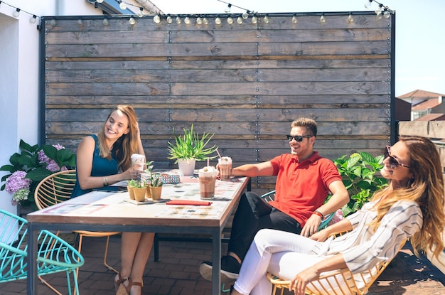 Freunde, die auf einer Party auf einer Terrasse etwas trinken