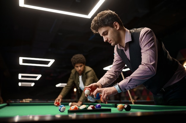 Freunde, die Billard spielen, junger Mann, der Ball sammelt