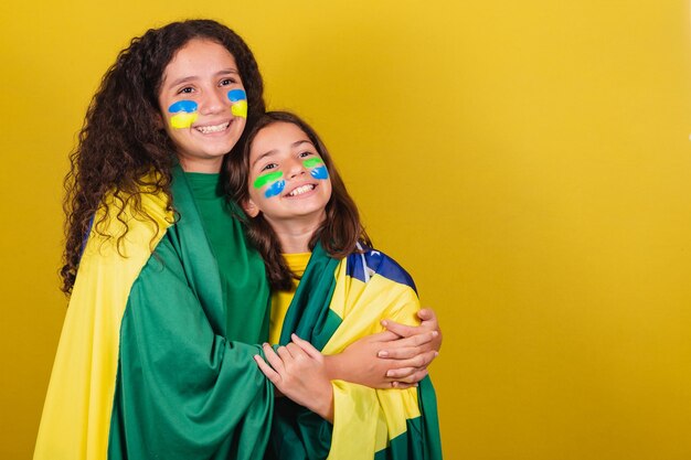 Freunde, die brasilianische Fußballfans unterstützen, lächeln und das Spiel der Olympischen Spiele der Weltmeisterschaft in Brasilien verfolgen