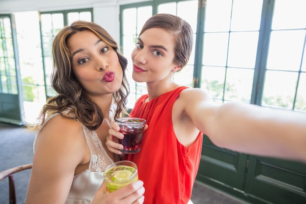 Freunde, die ein Selfie nehmen, während sie Cocktailgläser halten