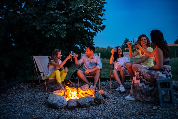 Freunde, die einen Toast um das Feuer haben.