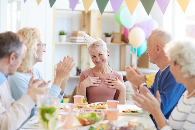 Freunde, die Hände für Geburtstagsfrau klatschen