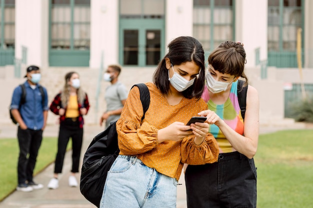 Freunde, die in der Schule soziale Medien am Telefon überprüfen