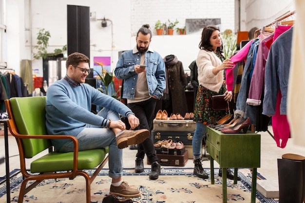 Foto freunde, die kleidung im vintage-kleidungsgeschäft auswählen