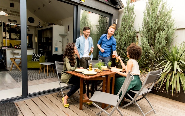 Freunde, die Lebensmittel grillen und Grillparty draußen genießen