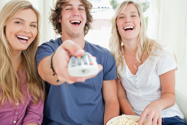 Freunde, die mit der Fernbedienung arbeiten, während sie lachen