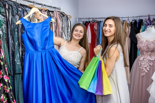 Freunde, die schönes Kleid im Laden betrachten