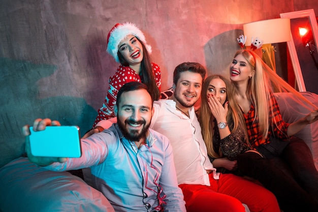 Freunde, die Selfie machen, während sie Weihnachten oder Silvester zu Hause feiern