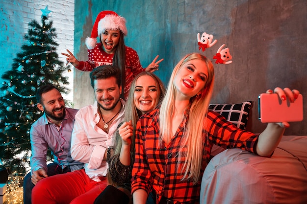 Freunde, die Selfie machen, während sie Weihnachten oder Silvester zu Hause feiern