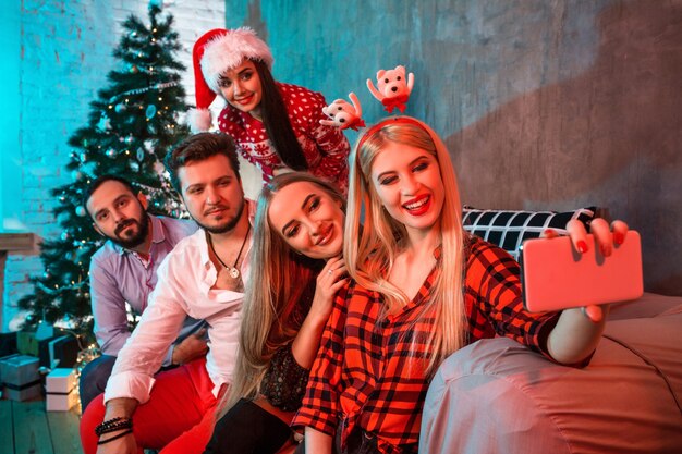 Freunde, die Selfie machen, während sie Weihnachten oder Silvester zu Hause feiern