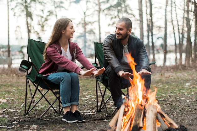 Freunde, die sich am Lagerfeuer erwärmen