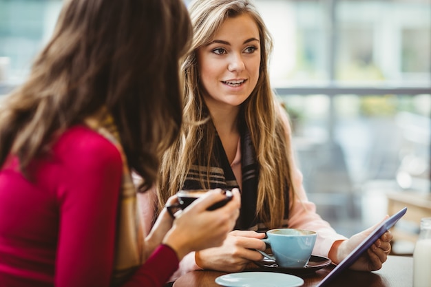 Freunde, die zusammen Tablette im Café verwenden