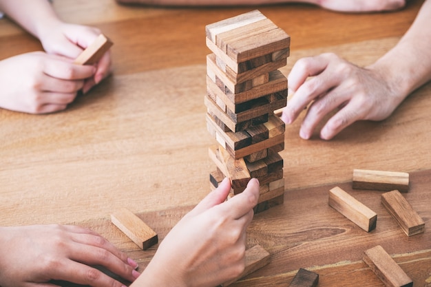 Freunde, die zusammen Tumble Tower Holzblockspiel sitzen und spielen