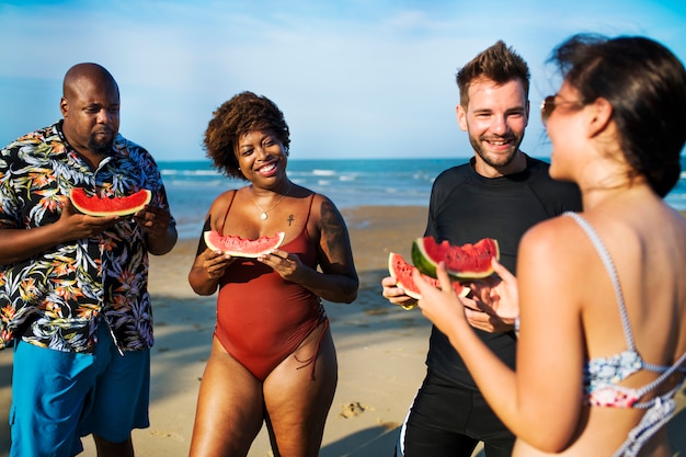 Freunde essen Wassermelone am Strand