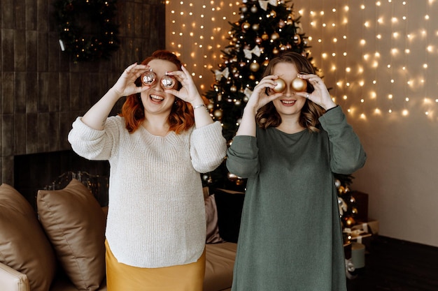 Foto freunde feiern weihnachten zu hause auf dem hintergrund eines schönen weihnachtsbaums