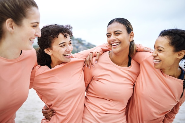 Foto freunde, fröhliche frauen und strand mit umarmung für komisches lachen, glückliches team und motivation für lächeln, unterstützung und vielfalt. gen z-athletengruppe, umarmung und lustig mit solidarität, bewegung und wellness