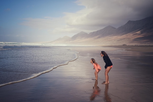 Freunde genießen am Strand gegen den Himmel